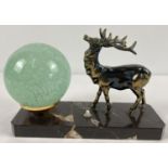 An Art Deco design table lamp with spelter figure of a stag and spherical green glass shade. On a