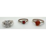 3 silver stone set rings. A cocktail ring set with a large square cut clear stone and a small
