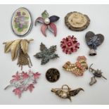 A collection of 12 vintage brooches in various designs, mostly floral and alpine themed. To