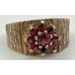 A vintage 9ct yellow gold ring with textured bark effect band set with a cluster of garnets in a