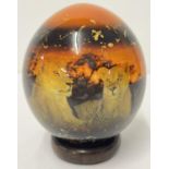 A painted and lacquered African Ostrich egg with lions at sunset scene and gold fleck detail with