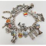 A vintage curb chain charm bracelet with 24 silver and white metal charms. To include a car, gun,