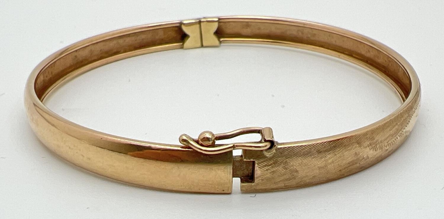 A vintage 9ct gold bangle with half floral engraving and safety clip (in need of attention) to - Image 2 of 3