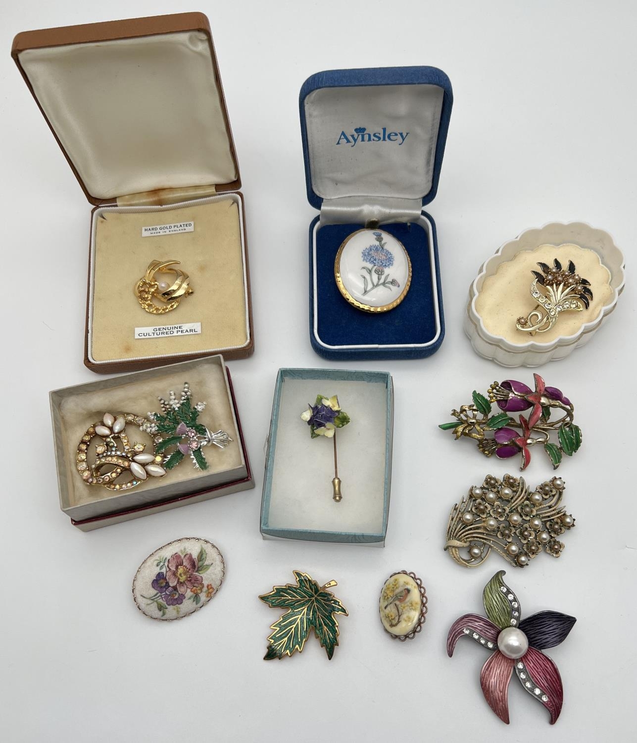 A collection of 12 vintage brooches in various styles, mostly floral, some stone set. To include