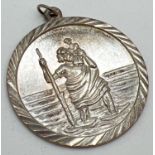 A vintage silver St. Christopher circular shaped pendant. Stamped "Silver" to reverse. Approx. 3cm