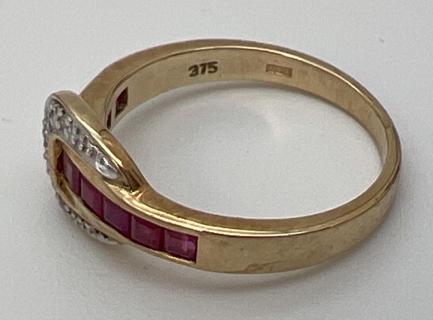 A 9ct gold ruby and diamond set buckle style dress ring. Band channel set with 5 square cut - Image 3 of 4