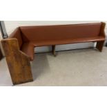 A corner bench seat as taken from a local pub, originally made from antique pews. Covered in tan