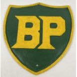 A large cast iron shield shaped BP wall plaque, painted green & yellow. With holes for fixing.