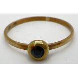 A small vintage 8ct gold ring with a bezel set sapphire. Stamped 333 inside band, ring size MÂ½.