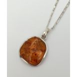 A 925 silver and amber pendant of modern design, on an 18" silver figaro curb chain with lobster