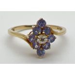A 9ct gold, tanzanite and diamond dress ring with a cluster setting. Central diamond surrounded by 8