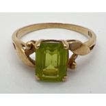 A vintage 9ct gold and peridot ring with central square cut stone in a twisted setting. Inside