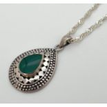 A 925 silver tear drop shaped pendant set with central green stone and with decorative mount. On