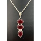 A large red 3 stone pendant in a white metal mount, on a 16" silver singapore chain with spring ring