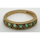 A vintage 9ct gold eternity ring set with 7 round cut emeralds. Fully hallmarked inside band. Ring