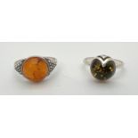2 silver and amber dress rings with central circular cabochons. A green amber set ring of