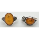 2 white metal amber set dress rings with decorative mounts, sizes O & P.