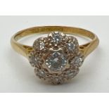 A vintage 18ct gold diamond cluster style ring set with 9 round cut diamonds. Total diamond
