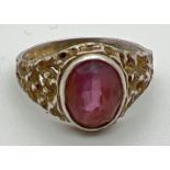 A vintage silver dress ring with bark effect mount set with an oval cut central amethyst stone.