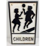 A cast iron "Children" wall plaque, painted black and white, with holes for fixing. Approx. 30.5cm x