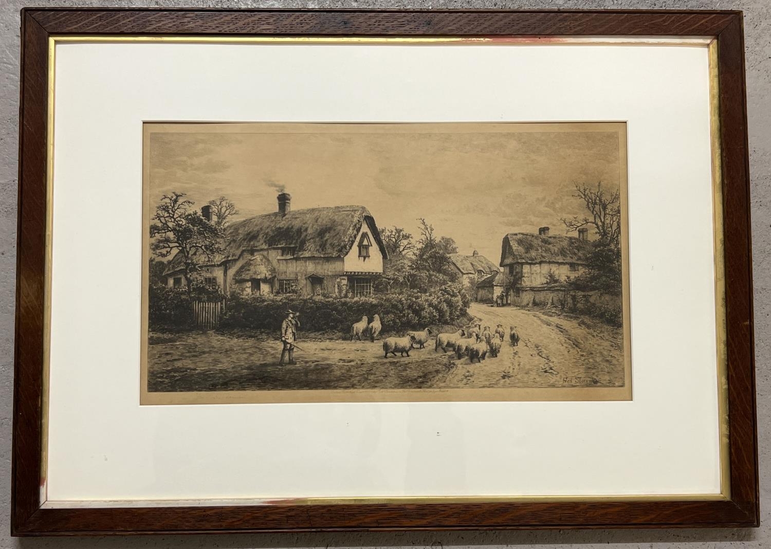 An antique framed and glazed Fred Slocombe engraving of a shepherd & sheep in a rural village scene.