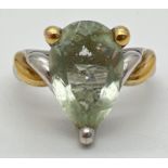 A modern design duo coloured silver cocktail ring set with a teardrop cut green amethyst. With twist