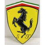 A shield shaped painted cast iron Ferrari wall plaque, with holes for fixing. Approx. 30cm x 20cm.