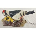 A decorative cast iron woodpecker door knocker with hand painted detail. Approx. 17cm long.