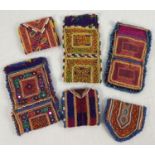 6 Central Asian heavily embroidered wrap pouches, in varying colours, sizes and designs. Some with