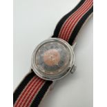 A vintage Doxa Shock proof wristwatch with canvas strap. Blue and orange face with luminous hands.