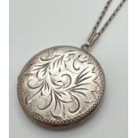 A vintage silver locket with foliate design engraving to front, on a 24" white metal chain. Locket