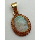 A 9ct gold cameo style carved opal pendant. Oval pendant with rope design to edge of mount.