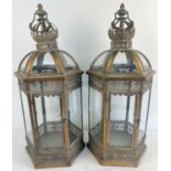 A large pair of Eastern style metal and glass panelled hexagonal lanterns with hinged doors.