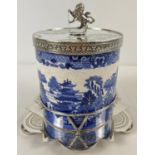 A Victorian ceramic lidded biscuit barrel in a decorative silver plated stand. Barrel with printed