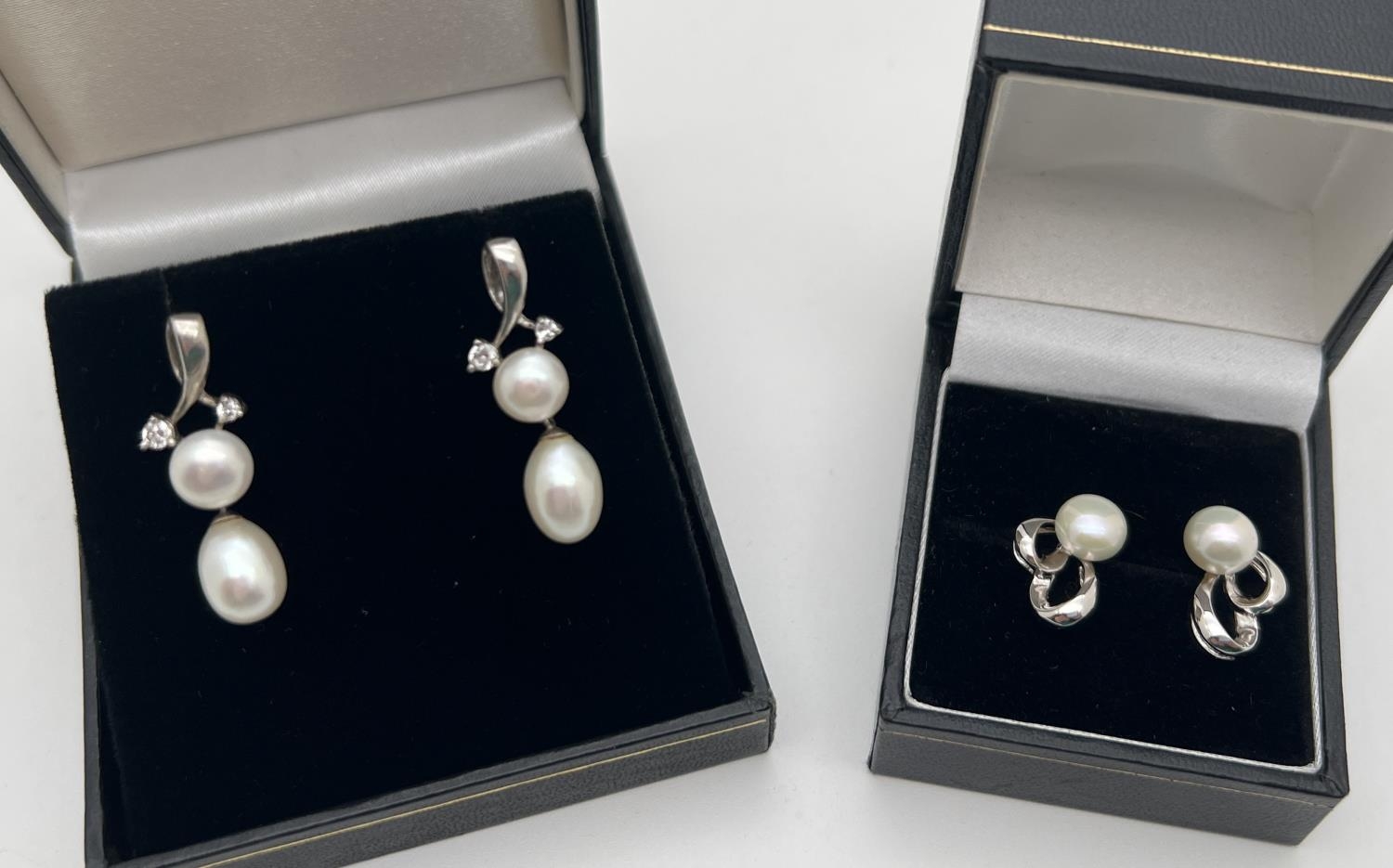 2 pairs of silver pearl set earrings. A pair of pearl drops with twist design and small clear