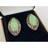 A pair of boxed Oriental style silver and jade stud earrings. Central marquise cut green jade in a