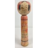 A vintage wooden red & black hand painted Japanese Kokeshi doll. Signed to underside. Approx. 18.5cm