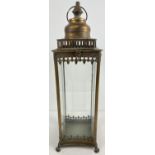 A large slim square shaped metal and glass panelled lantern with hinged lid. 4 concave shaped