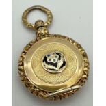 An Edwardian gold locket with floral design and engine turned detail. Central flower detail to front