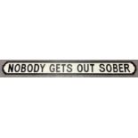 A 'Nobody Gets Out Sober' wooden wall sign, painted black & white, in the style of an old street