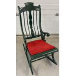 A vintage painted wood rocking chair with spindle back and turned detail. Painted dark green with
