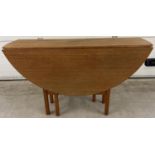 A vintage 1970's teak drop leaf slim dining table with gateleg supports. Approx. 74.5cm tall x 122cm