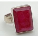 A modern silver dress ring set with a rectangular cut ruby. Inside of band marked 925. Ring size