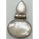 A modern design large silver pendant set with white Mother Of Pearl shell. Marked 925 to pendant.