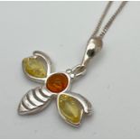 A small silver and amber pendant necklace modelled as a bumble bee and set with lemon & cognac