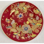 A 10.5" red and gilt floral patterned plate by Spode, England. Red ground with floral detail in