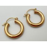 A pair of 9ct gold hollow hoop earrings with hinged posts, stamped 375. Approx. 3.2cm diameter,