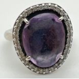 A 925 silver Glamorous Legacy ring by Pandora. Central purple faceted stone surrounded by small