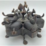 An Oriental bronze 6 sectional spice box with finials modelled as peacocks and raised on 6 claw