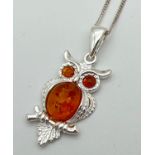 A 925 silver and amber pendant in the shape of an owl, on an 18" silver curb chain. Pendant